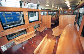 キハ140-2066の客室内。キハ147-1045も含め車内中央に木製のカウンターテーブルとベンチを据えた展望スペースを設置。足元に広がる窓が開放感を演出する